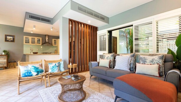 A modern living room with a grey sofa, wicker chairs, and a round coffee table. - Villa Madison | Port Douglas (PORT DOUGLAS)