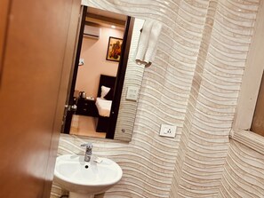 A bathroom with a white sink, a mirror, and a textured wall.