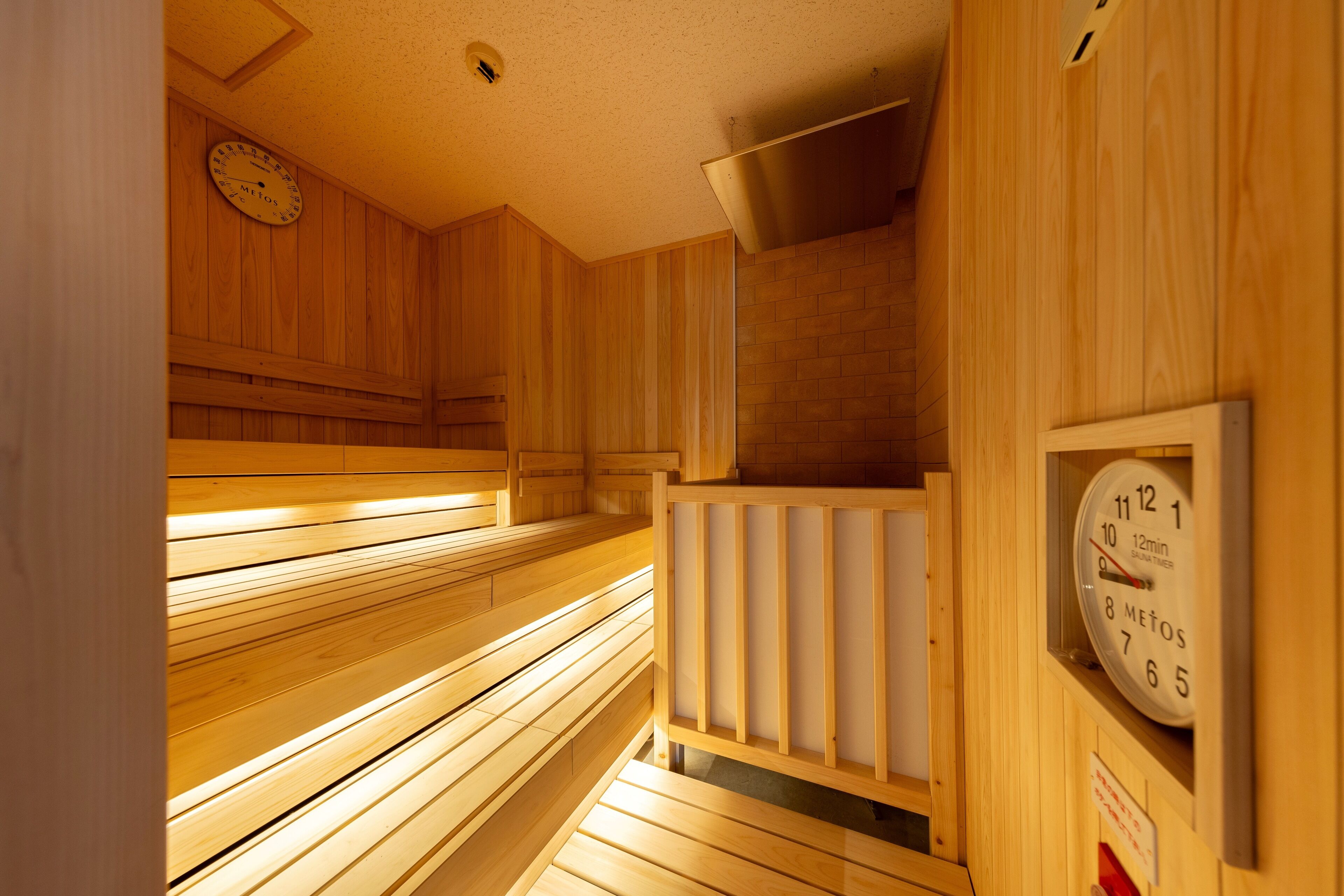 A sauna with wooden benches and a clock on the wall.
