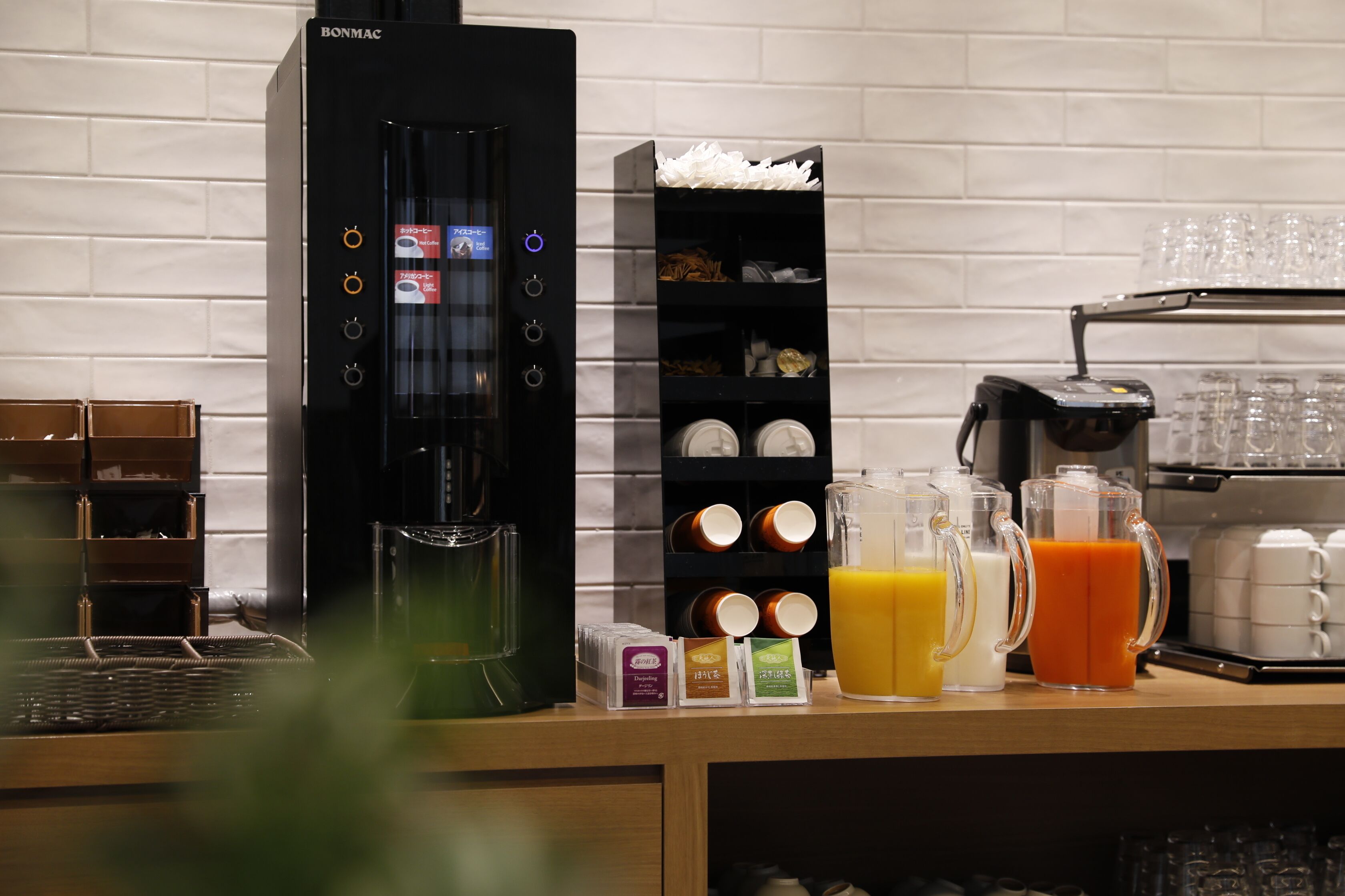 A coffee machine, a coffee station, and a juice dispenser in a kitchen area.