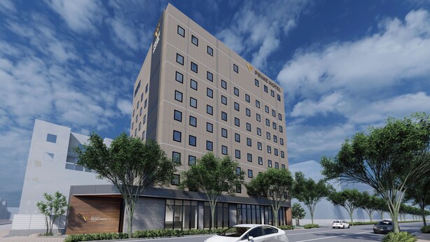 A modern hotel building with a prominent sign, multiple windows, and a parking area with cars. - Shimanami PRIME HOTEL IMABARI (Imabari)