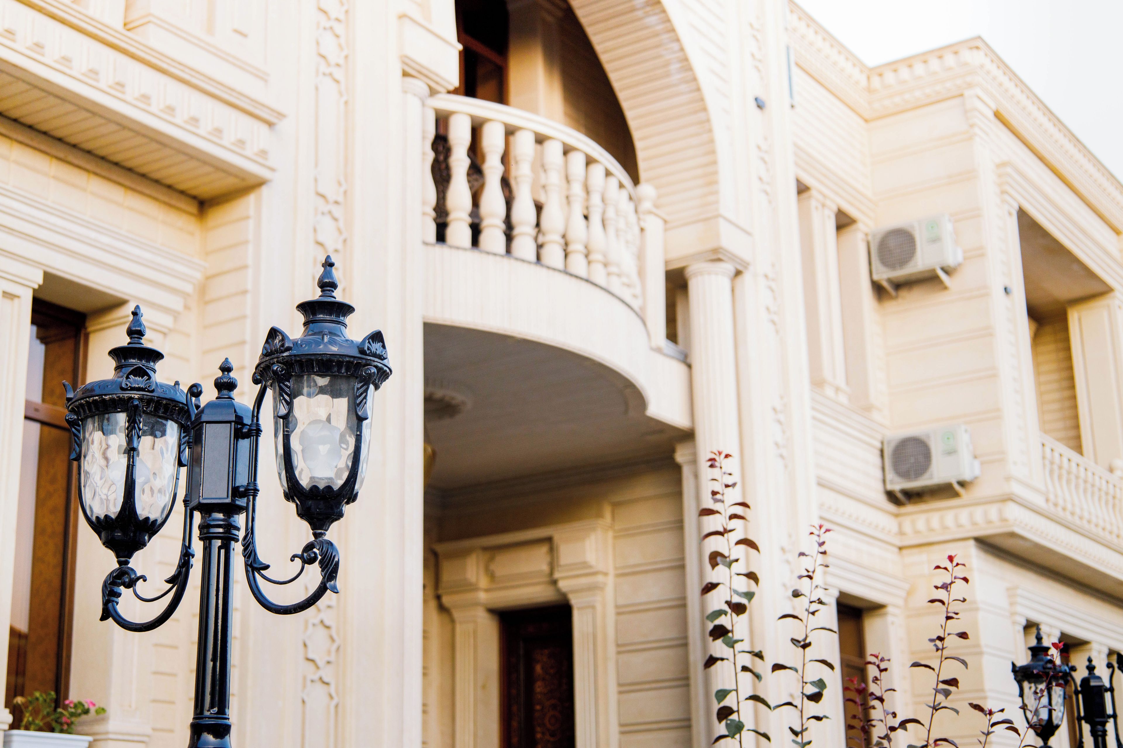 A building with ornate architectural details, including a balcony and multiple air conditioning units.