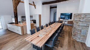A spacious dining area with a long wooden table set for a meal, surrounded by modern chairs. - Gute Auszeit - Ferienwohnung Lichtblick (Borken)
