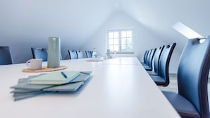 A conference room with a long table, chairs, and a window. - Gute Auszeit - Ferienwohnung Weitblick (Borken)