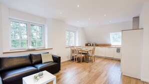 A modern apartment with a living room, dining area, and kitchen. - Gute Auszeit - Ferienwohnung Weitblick (Borken)