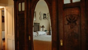 A bedroom with a wooden wardrobe, a bed, and a nightstand with a lamp. - Historic LaMothe Landing & Farmhouse|SPAC|Track| (Greenfield Center)