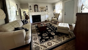 A living room with a fireplace, white furniture, and a patterned rug. - Historic LaMothe Landing & Farmhouse|SPAC|Track| (Greenfield Center)