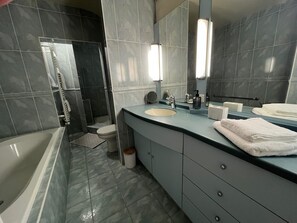 Ein modernes Badezimmer mit Badewanne, Waschbecken und Spiegel.