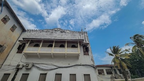 A building with a balcony, multiple windows, and visible electrical wiring.