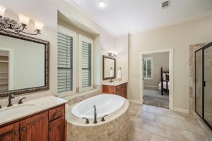 A spacious bathroom with a large bathtub, two sinks, and a walk-in shower. - Historic Grapevine 3-bedroom house 4 minutes walk to Historic main street. (Grapevine)
