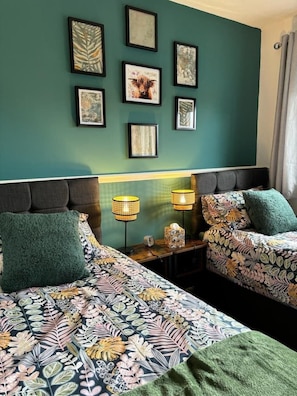 A hotel room with two beds, a green wall, and framed artwork. - Stylish home in Linlithgow | Near Edinburgh Airport | Free parking | Free WiFi (Linlithgow)