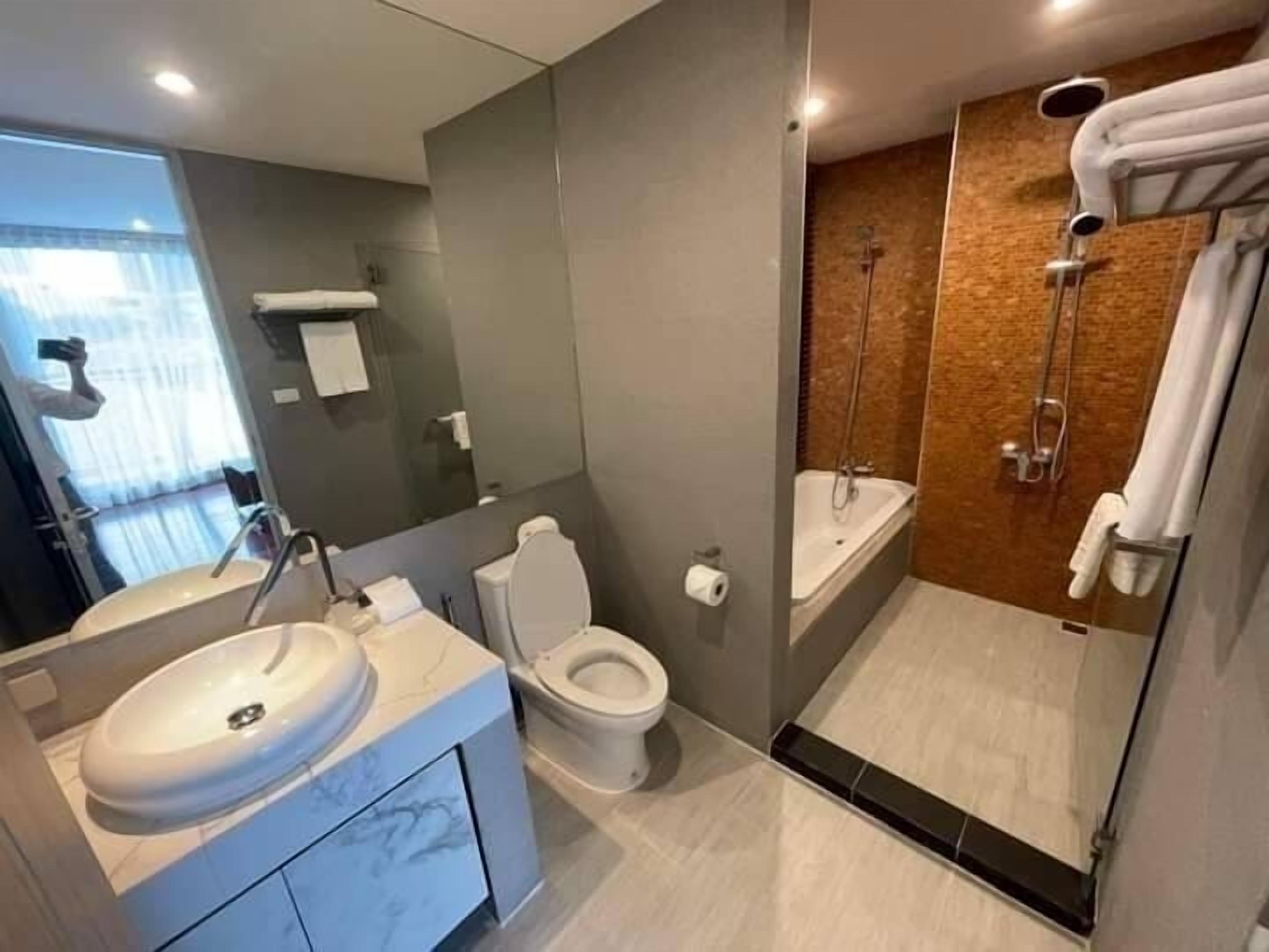 Un baño moderno con lavamanos, inodoro y cabina de ducha.