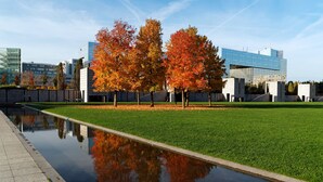 A modern building with glass facades and a reflection in a water feature. - The Retro Romantic, by Veeve (Paris)