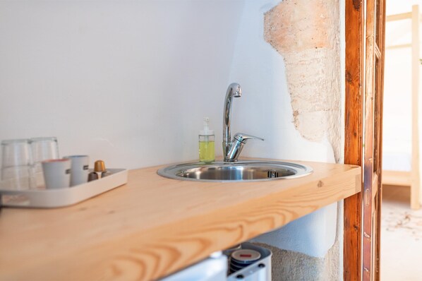 A kitchen with a wooden countertop, a stainless steel sink, and a bottle of dish soap. - Marthas Delight Rooms (Chania)