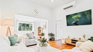 Un salon moderne avec un canapé, une table basse et un téléviseur.
