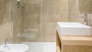 A modern bathroom with a glass-enclosed shower, a wooden vanity with a sink, and a toilet. - Lux Caracciolo (Naples)
