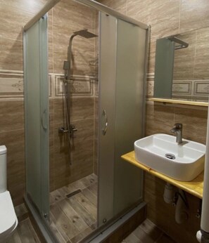 A bathroom with a glass-enclosed shower, a white sink, and a mirror above it. - MOOD HOTEL KAZBEGI (Kazbegi)