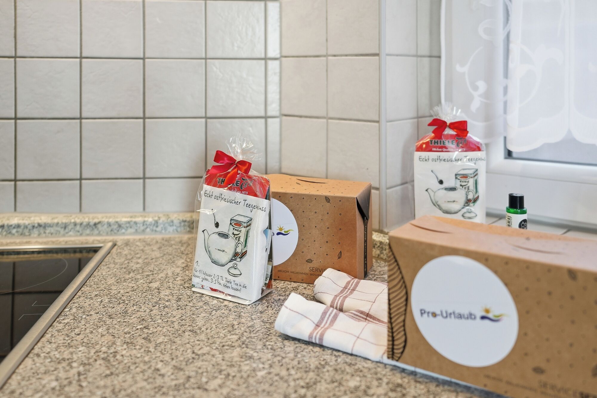 A kitchen counter with three gift boxes, one with a tea set and another with a tea kettle.