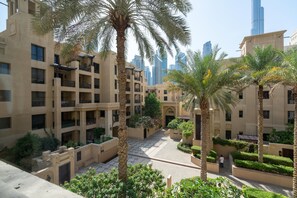 Stunning urban retreat with a symmetrical facade, surrounded by lush greenery and a beautifully paved courtyard.