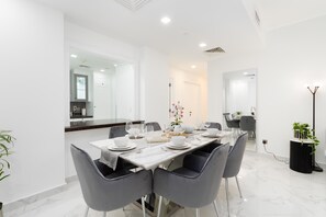 Formal dining area with a table set for four, featuring matching chairs and fine china.