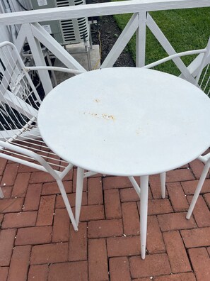 A white metal table with four legs, surrounded by white metal chairs, set on a brick patio. - King Bedrooms, Two Blocks to Gulf, Shopping, and Dining in Old Naples
 (Naples)