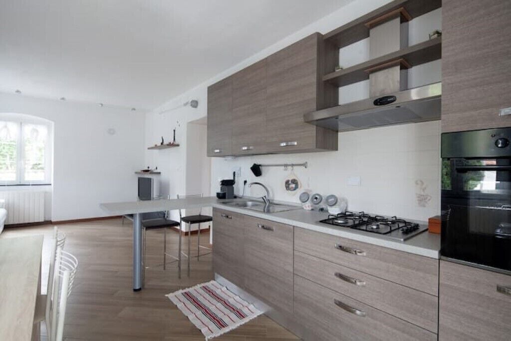 A modern kitchen with a central island, built-in cabinets, and a gas stove.
