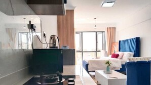 A modern kitchen with a gas stove, a coffee machine, and a large window providing natural light. - Comfort Homestay Kilimani (Nairobi)