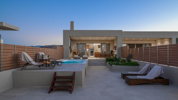 Une terrasse sur le toit avec une piscine, des chaises longues et un espace repas.
