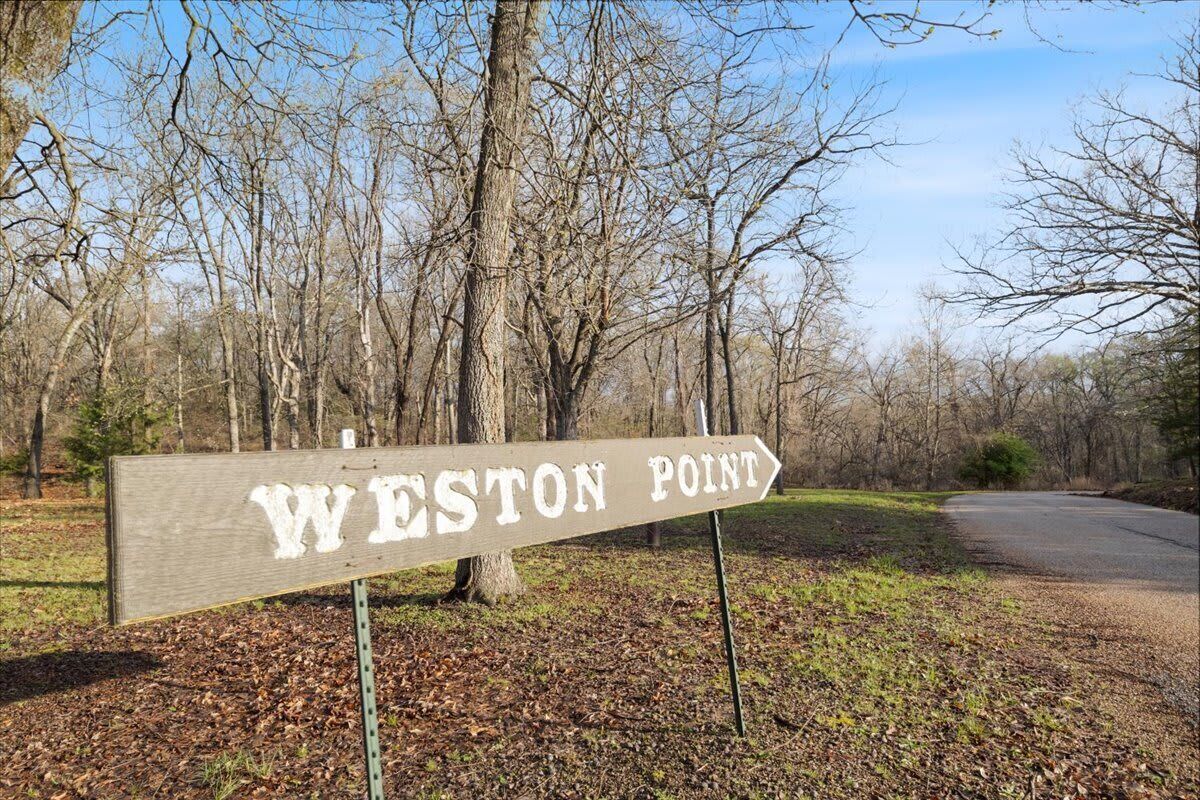 A wooden directional sign with "WESTON POINT" written on it, pointing to the right.