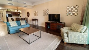 Ein Wohnzimmer mit Sofa, Couchtisch, Fernseher und Wanddekoration.