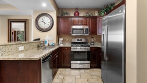 A kitchen with granite countertops, stainless steel appliances, and wooden cabinets. - Beachfront Beauty 2BR 2BA Condo with Kitchen (North Myrtle Beach)