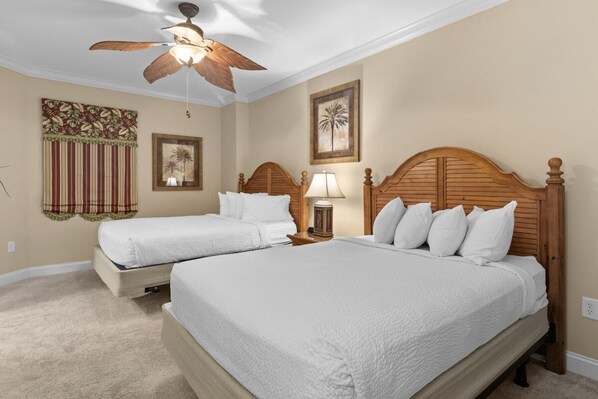 A hotel room with two beds, a ceiling fan, and a small table with a lamp. - Beachfront Beauty 2BR 2BA Condo with Kitchen (North Myrtle Beach)