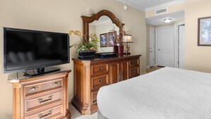 A bedroom with a bed, a dresser with a mirror, a television, and a ceiling fan. - Beachfront Beauty 2BR 2BA Condo with Kitchen (North Myrtle Beach)