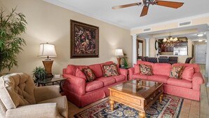 A living room with a red sofa set, a wooden coffee table, and a patterned rug. - Beachfront Beauty 2BR 2BA Condo with Kitchen (North Myrtle Beach)
