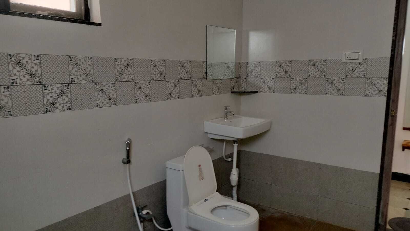 A bathroom with a toilet, a sink, and a shower.