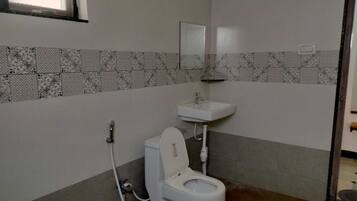 A bathroom with a toilet, a sink, and a shower.