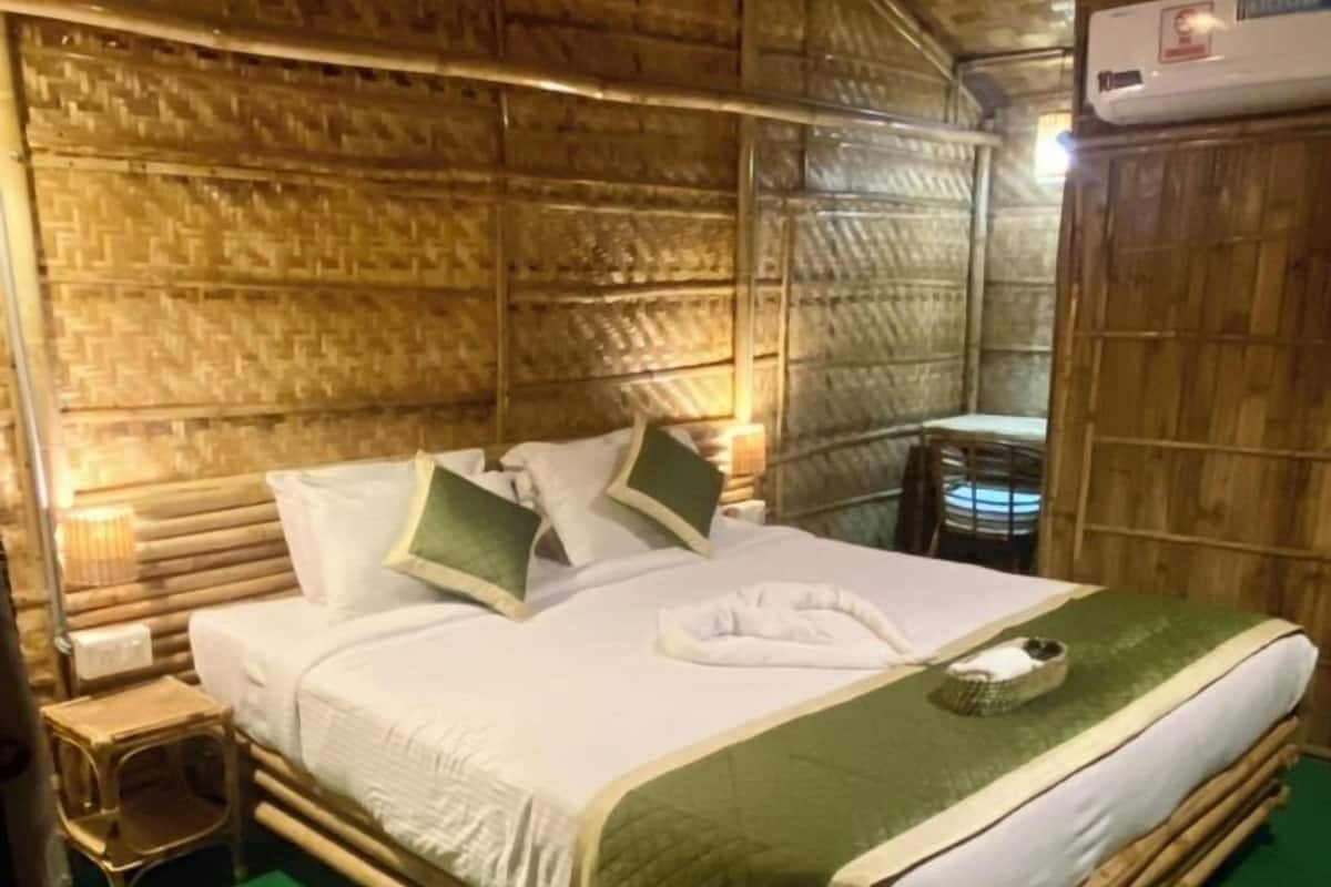 A wooden room with a bed, a nightstand, and a chair.