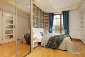 Comfortable bed, wood furniture, and large wardrobe.