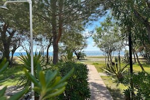 Stroll along the serene pathway to a tranquil body of water surrounded by lush greenery and trees.
