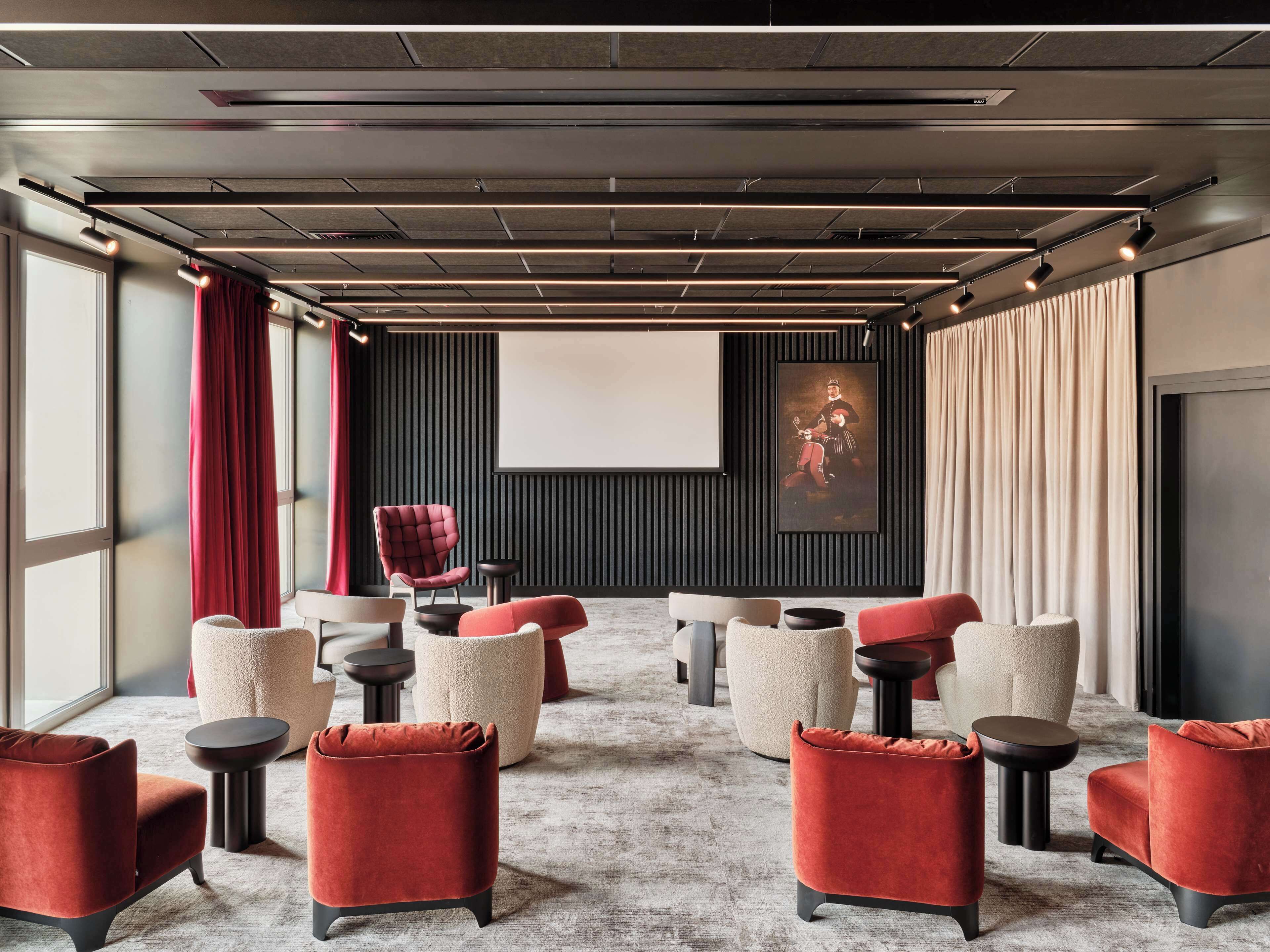 Una sala de cine moderna con una pantalla grande, asientos cómodos y un diseño minimalista.