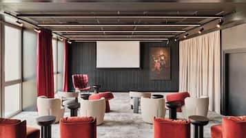 Una sala de cine moderna con una pantalla grande, asientos cómodos y un diseño minimalista.