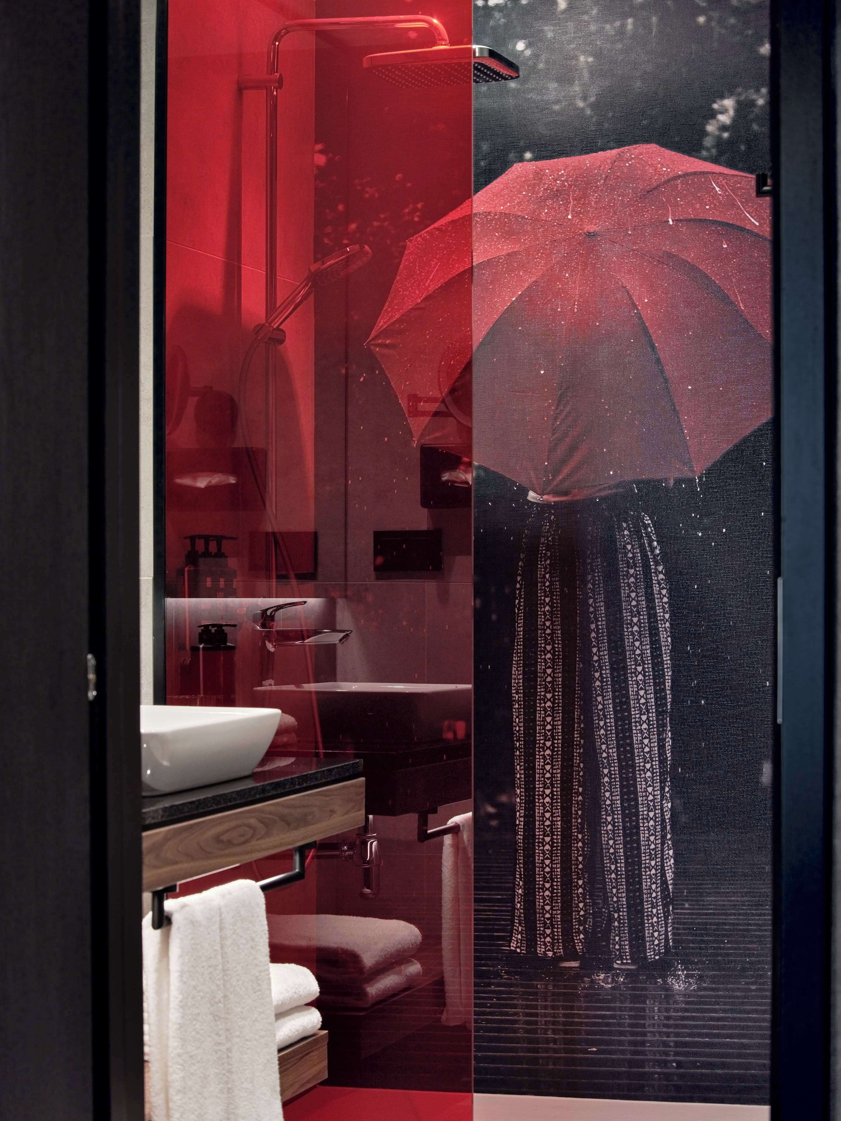 Een badkamer met een grote spiegel, een wastafel en een handdoekhouder.