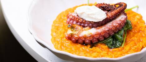 Un plato de comida con pulpo y espinacas.
