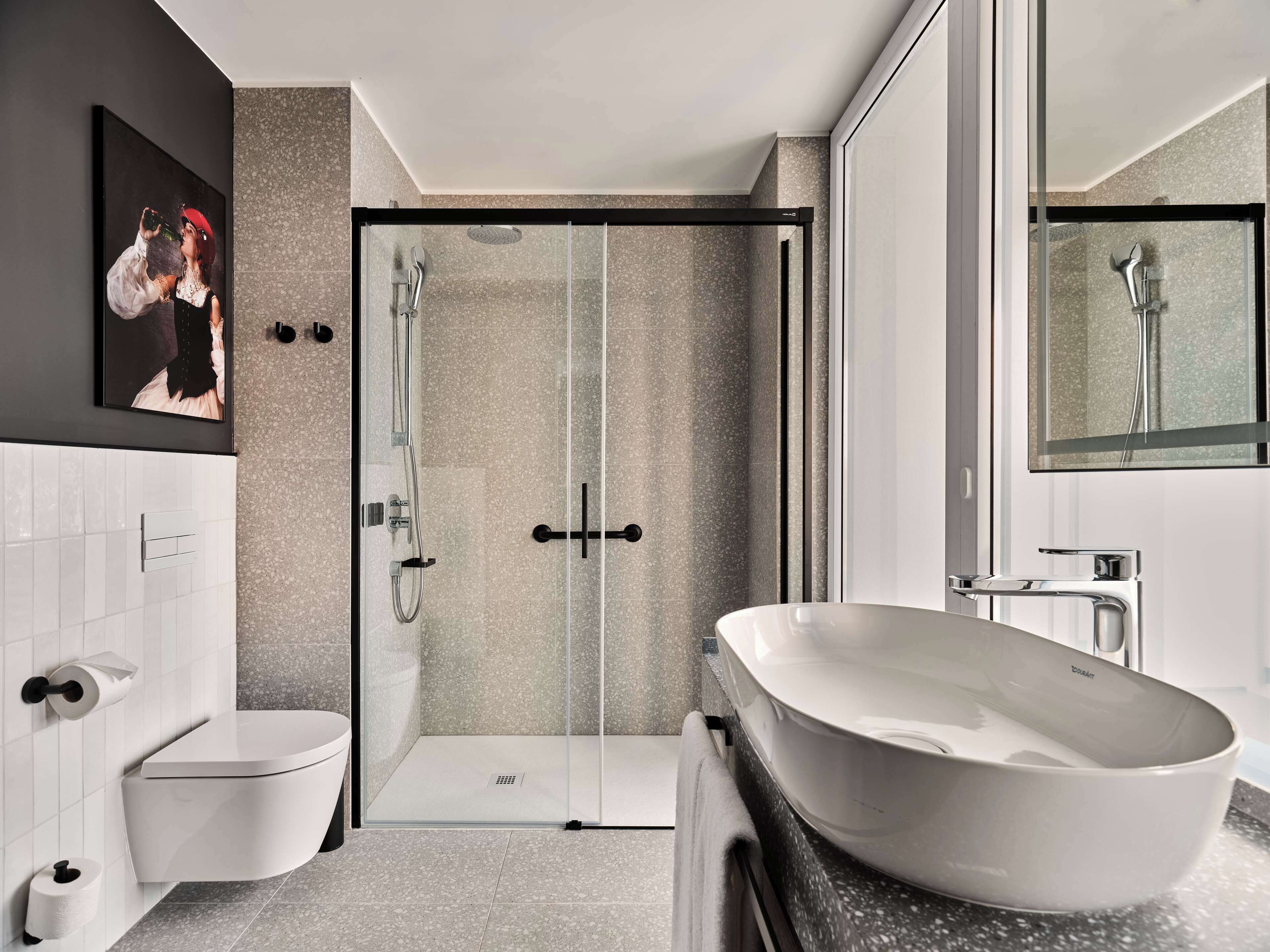 A modern bathroom with a freestanding bathtub, a glass-enclosed shower, and a toilet.