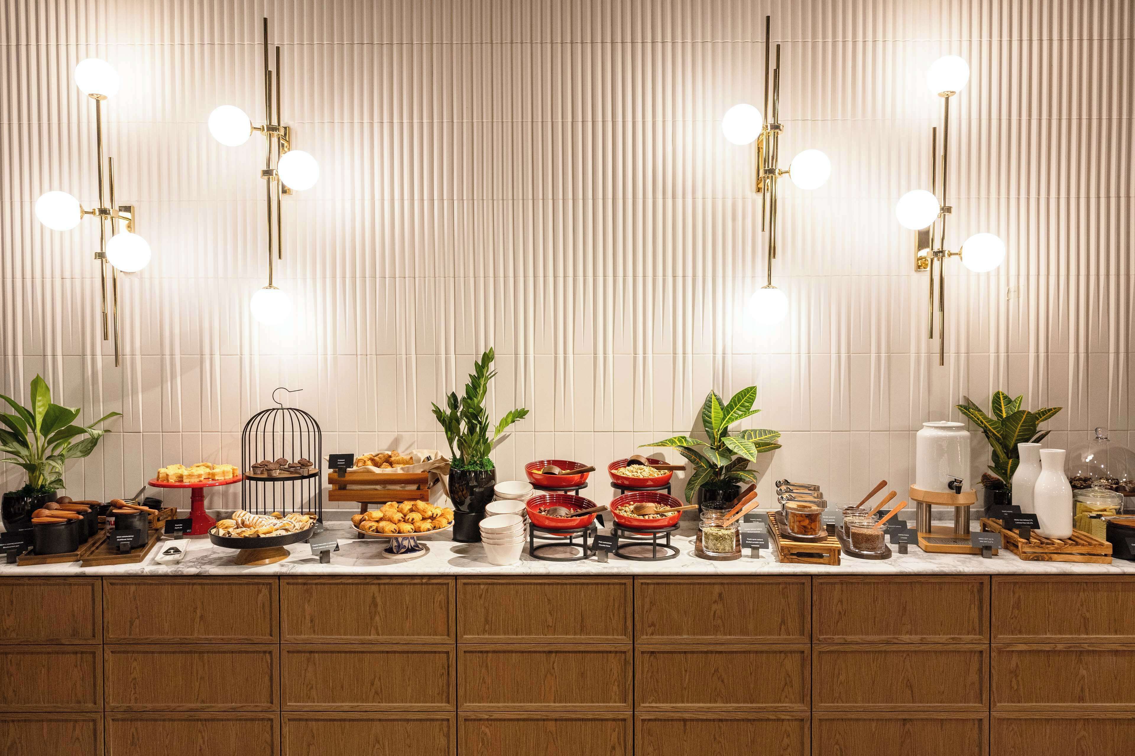Una mesa de buffet con diversos alimentos y un aparato de iluminación decorativo.