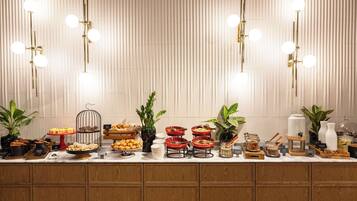 Una mesa de buffet con diversos alimentos y un aparato de iluminación decorativo.