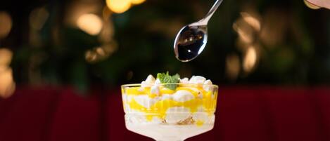 Un postre en un bol de vidrio con una cuchara encima.