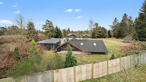 A rural property with a fenced yard, a house with a sloped roof, and a small building in the background. - 4 bedroom cozy home in Ans By (Ans By)