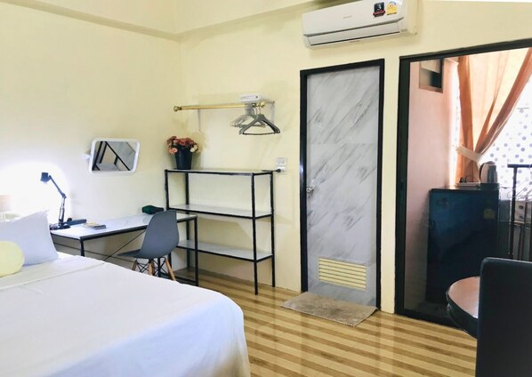 A hotel room with a bed, desk, chair, and a wardrobe. - Private room Large bed, en-suite bathroom, Kitchen, parking, near night bazaar. (Chang Wat Chiang Mai)