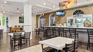 A restaurant with a bar area, multiple tables and chairs, and a television screen mounted on the wall. - Comfortable 3BR townhouse w/ pvt patio (Davenport)